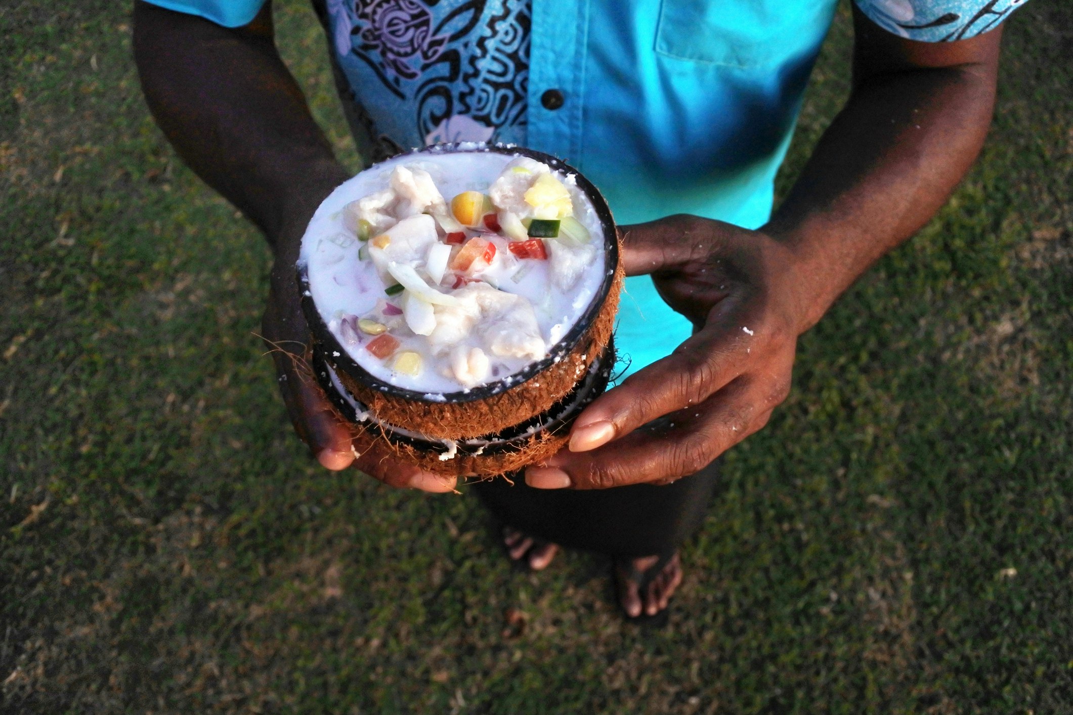Indigenous Fijian Man serves Fijian Food, Kokoda (Raw Fish Salad)